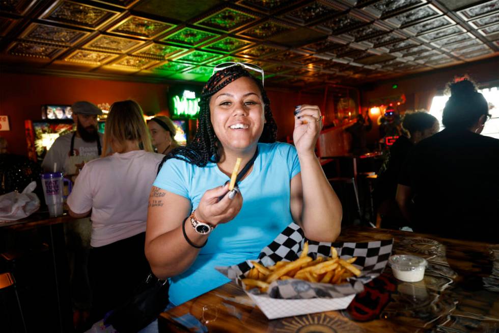 Customer Chandra Weekly of Las Vegas eats fries at Sliced Pizza, Sunday, May 8, 2022, in Las Ve ...