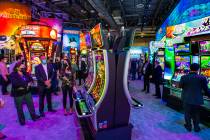 Attendees learn about the newest slot within the Scientific Games Corp. display area during day ...