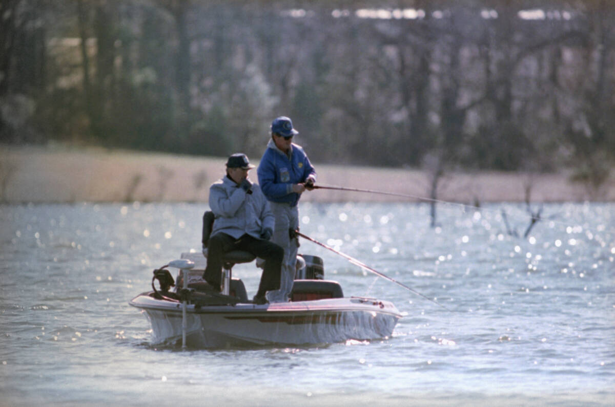 President George Bush uses a one-handed casting method during a New Year's Day bass fishing tri ...