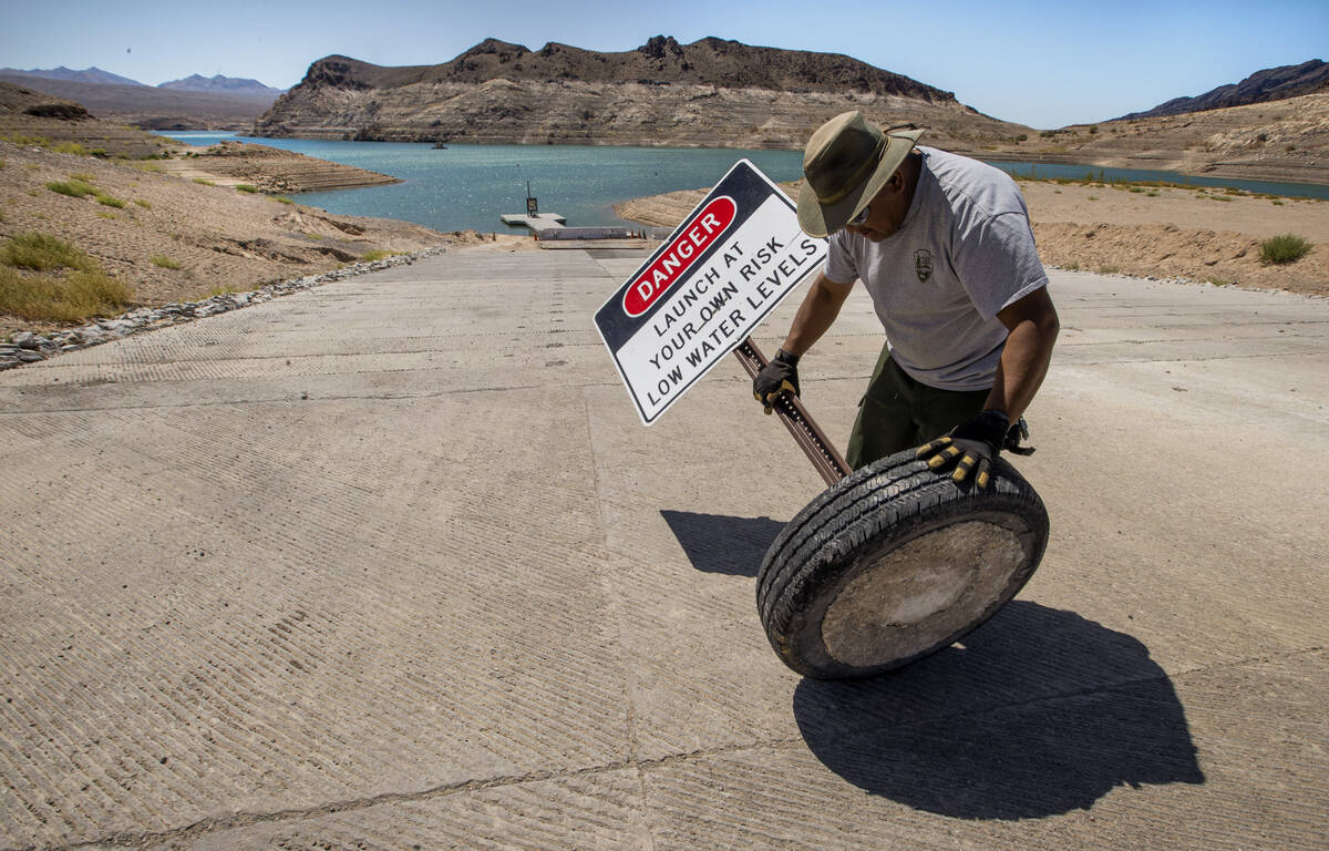 Rommel Garcia with the National Parks Service rolls away signage as the boat launch in Echo Bay ...