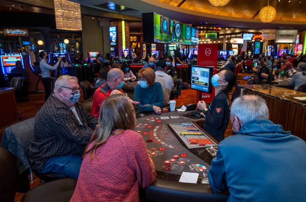A dealer reacts to a winning hand as guests play Ultimate Texas Hold’Em at Red Rock Casi ...