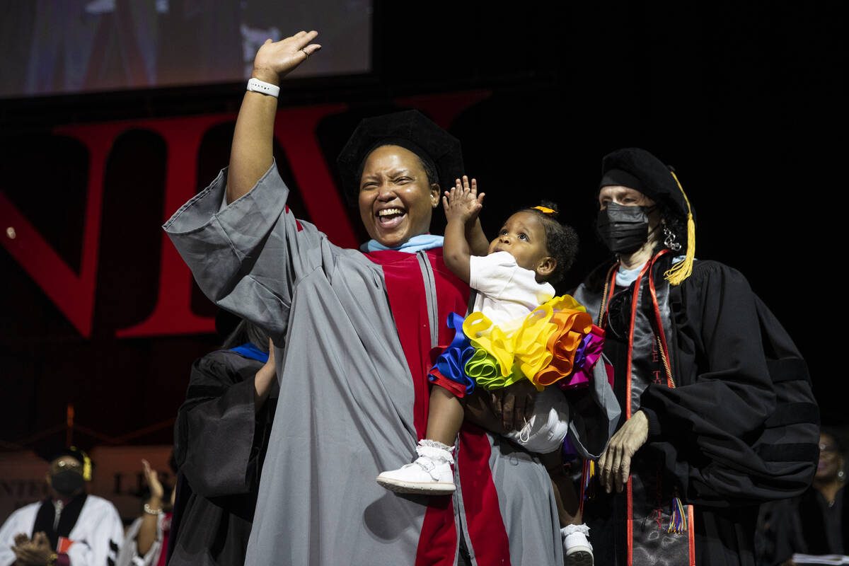 Postgraduate Ebony Sherman, with her 1-year-old daughter Makenzie, waves at the crowd after bei ...