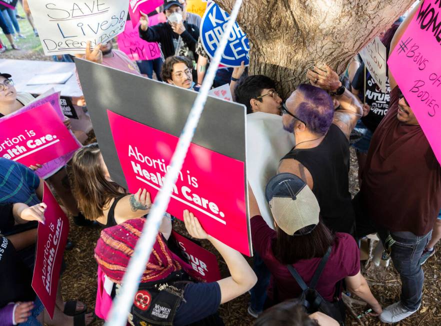 Demonstrators clash with an anti-abortion activist, middle, protest during a pro-abortion rally ...