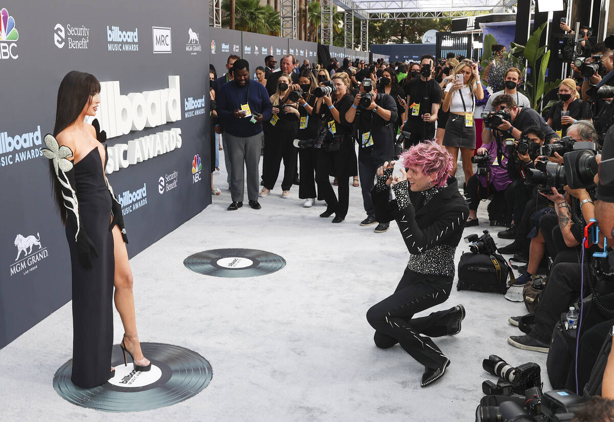 Megan Fox, left, poses as Machine Gun Kelly mimics photographers on from the red carpet for the ...