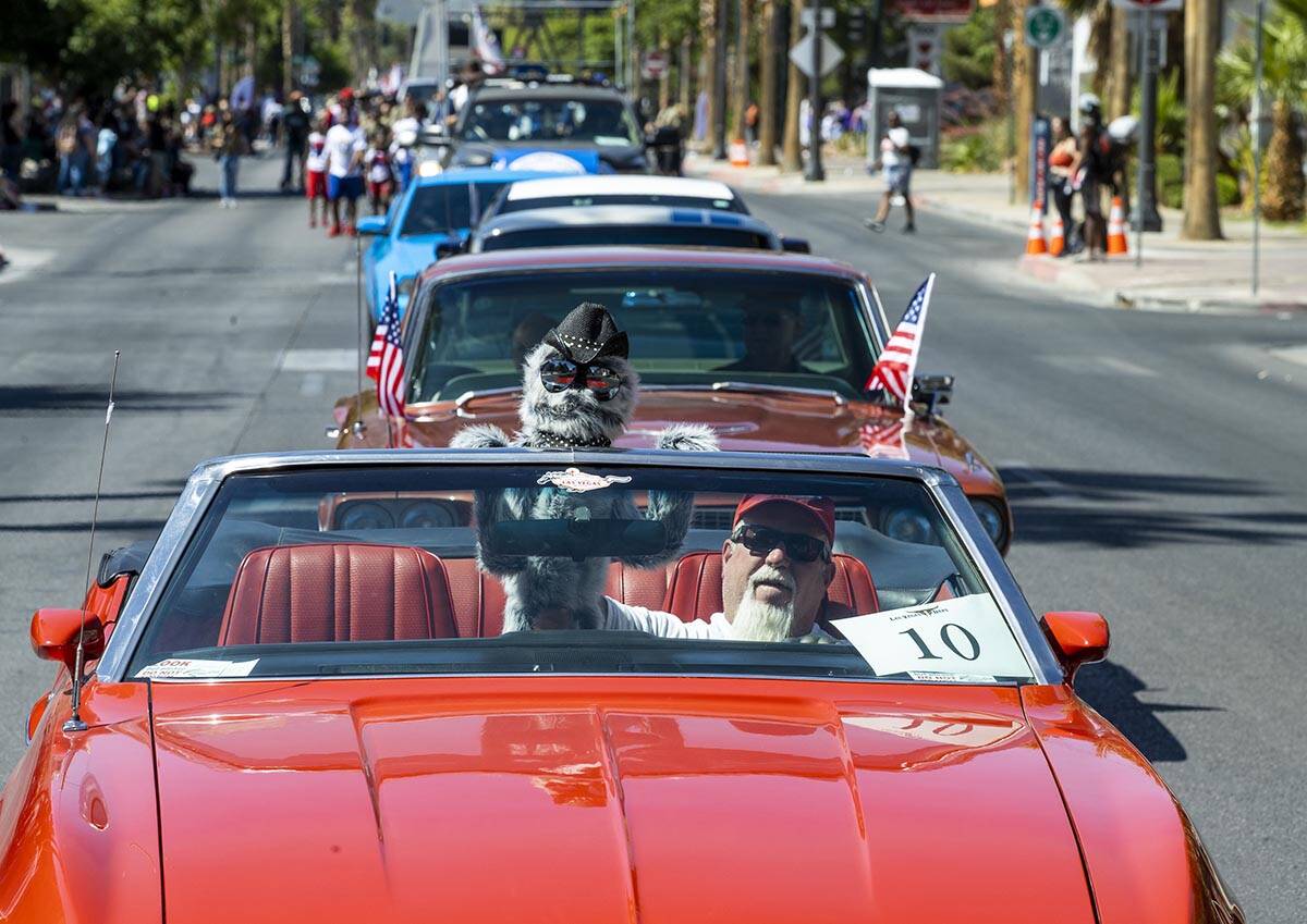 A participant and his puppet lead a line of classic Mustangs in the Las Vegas Day Parade movin ...