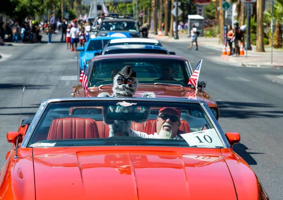 A participant and his puppet lead a line of classic Mustangs in the Las Vegas Day Parade movin ...