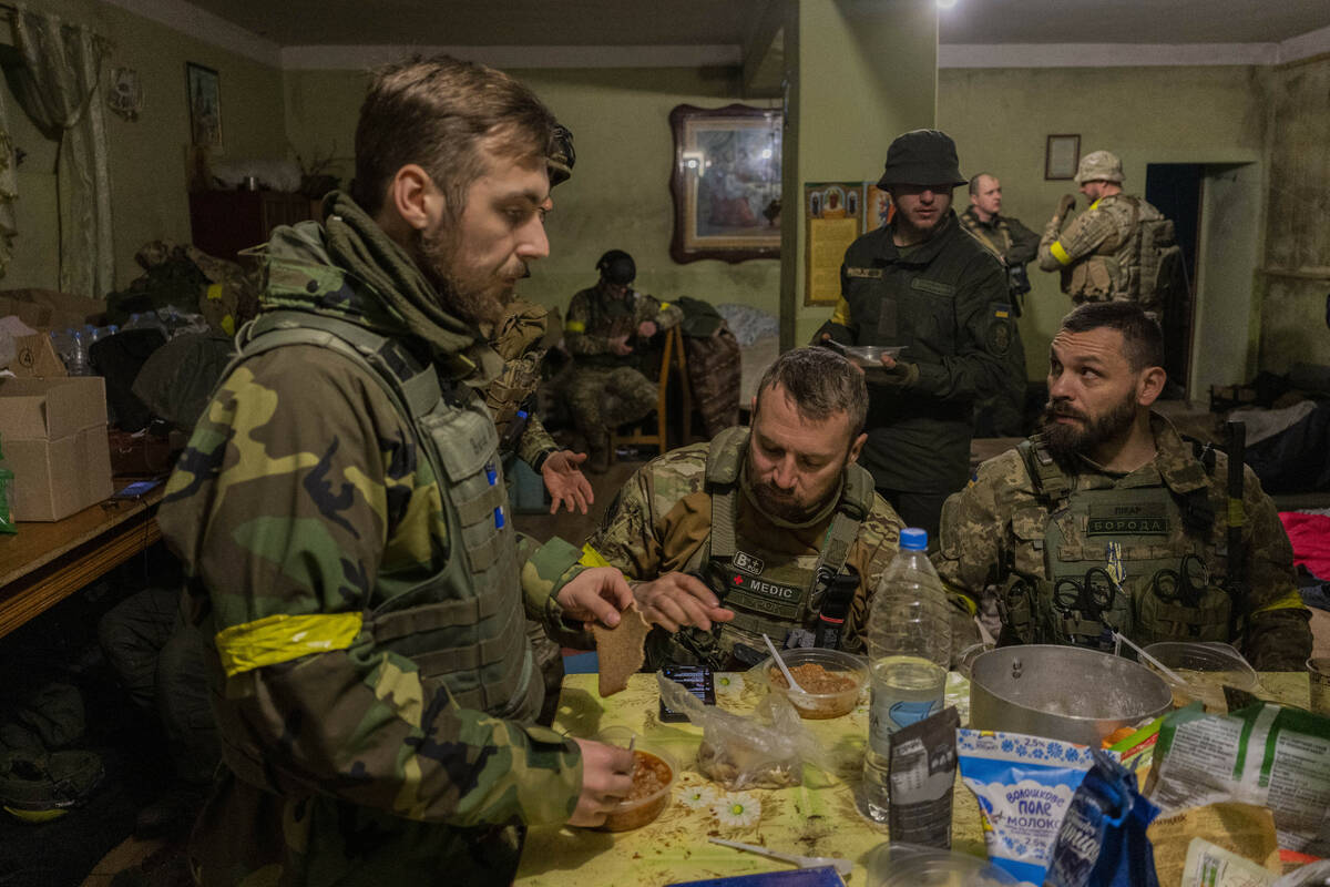 Ukrainian National Guard soldiers gather in a house used as temporary base in a recently retake ...