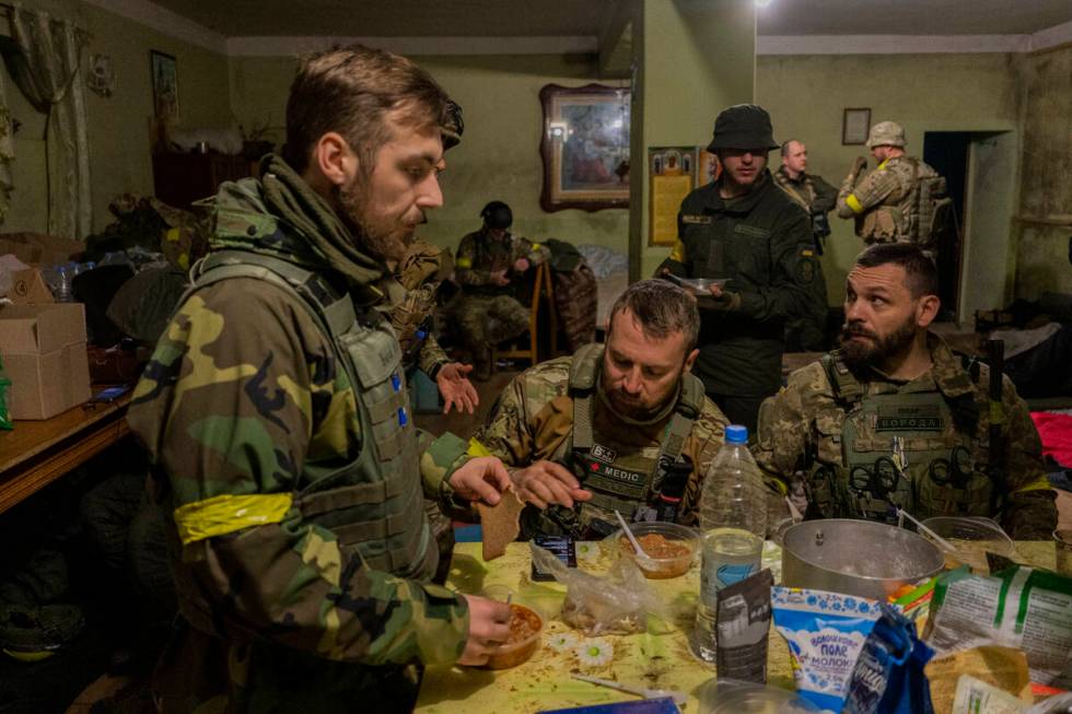 Ukrainian National Guard soldiers gather in a house used as temporary base in a recently retake ...