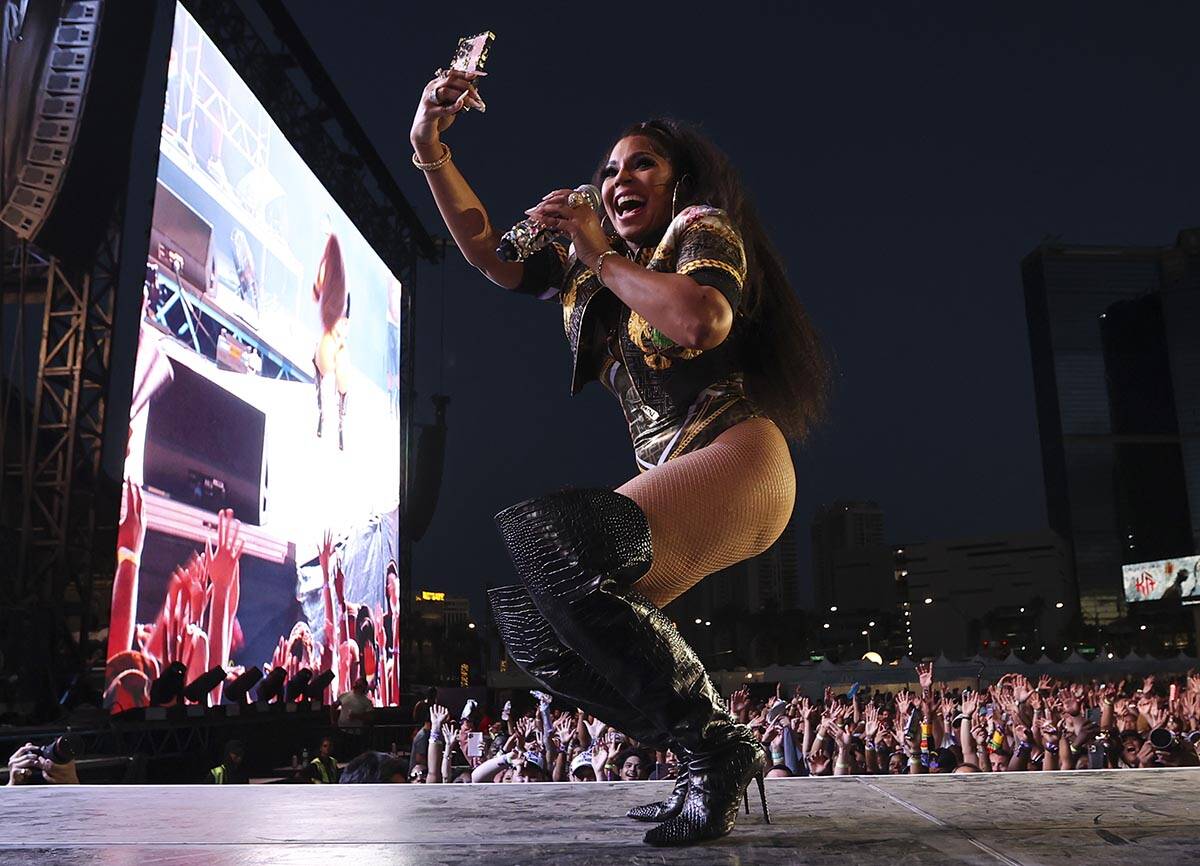 Ashanti records with her phone during the Lovers & Friends music festival on Saturday, May ...