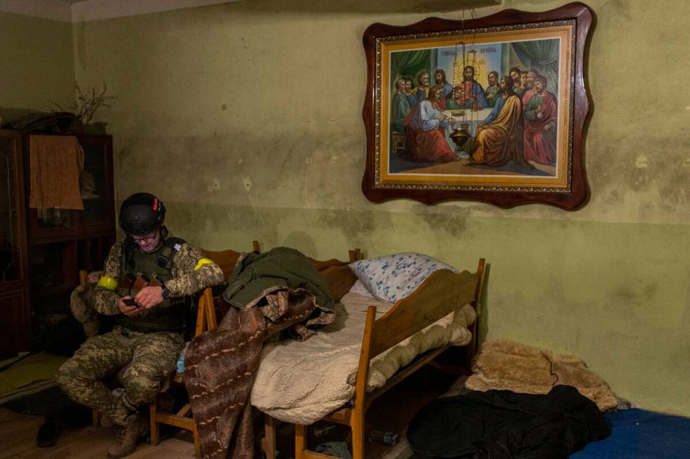 A Ukrainian National Guard soldier takes a break in a house used as temporary base in a recentl ...