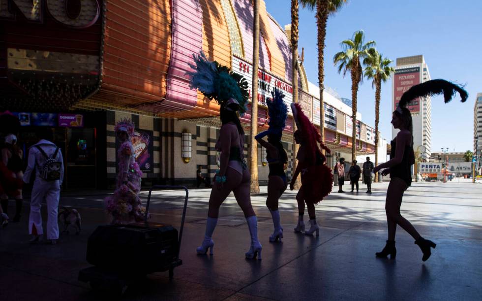 Participants in the Las Vegas Showgirl parade walk along the Fremont Street Experience on Sunda ...