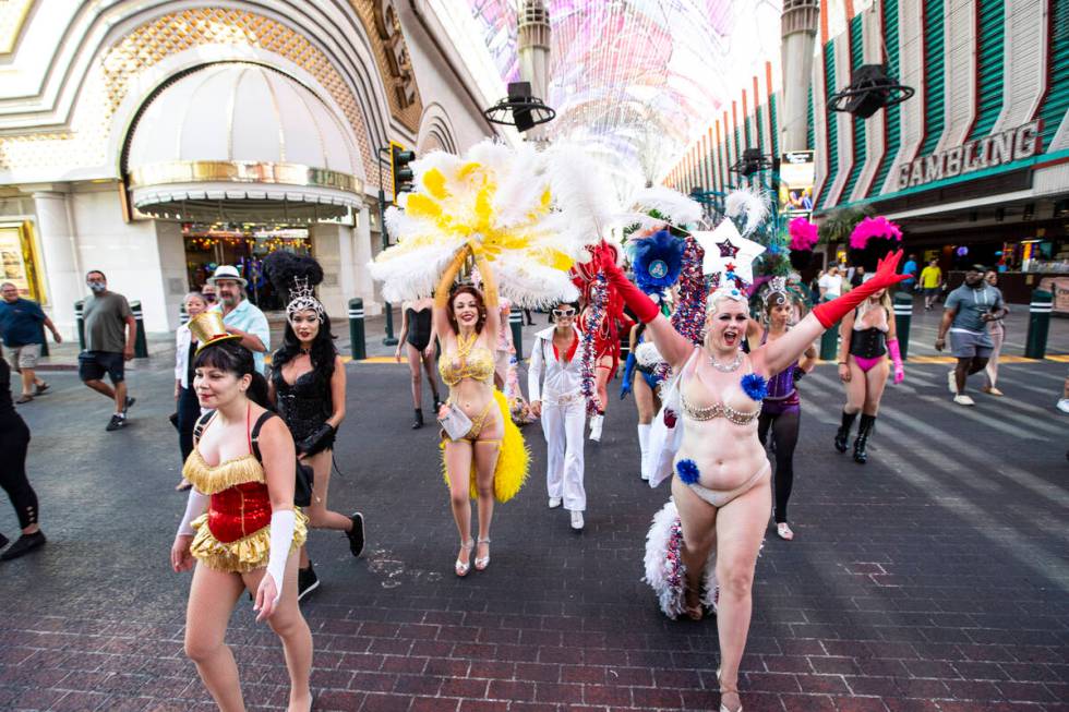 Participants in the Las Vegas Showgirl parade walk along the Fremont Street Experience on Sunda ...