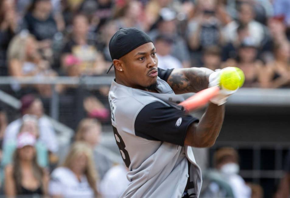 Las Vegas Raiders Josh Jacobs (28) connects on a hit during a charity softball game versus the ...