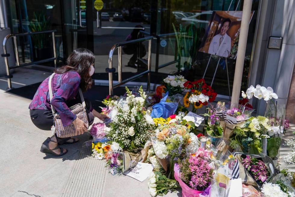 Grace Hung, a patient of Dr. John Cheng, places flowers at a memorial honoring him outside his ...