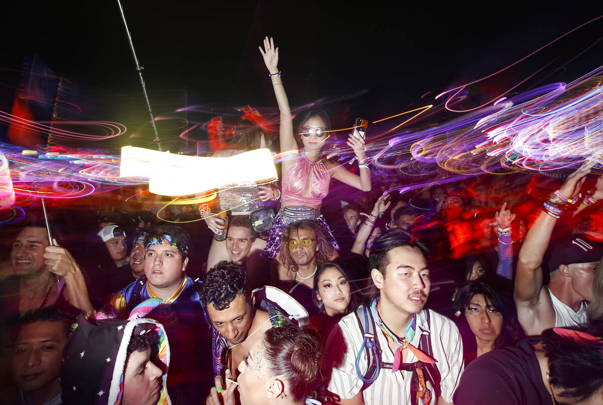 People dance as Kaskade performs at the Kinetic Field stage during the final day of the Electri ...