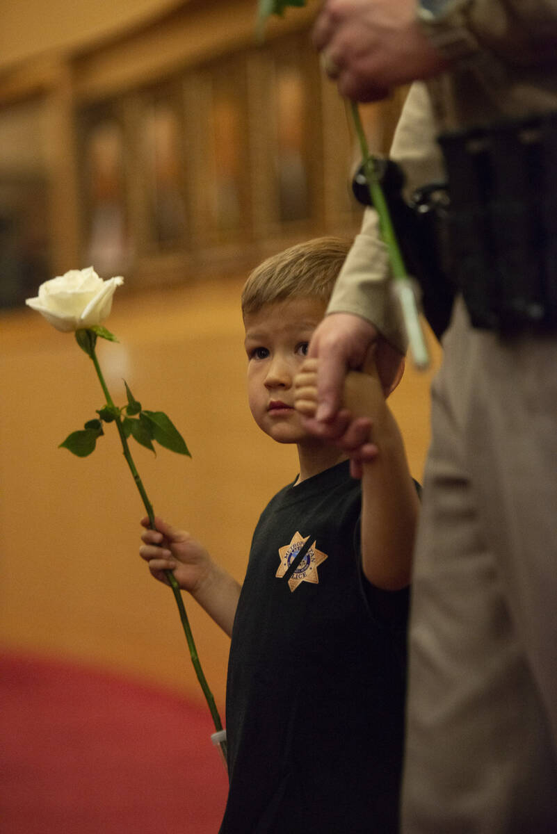 Liam Walker, 4, holds his father Lt. Dave Walker's hand as they enter the Las Vegas City Counci ...