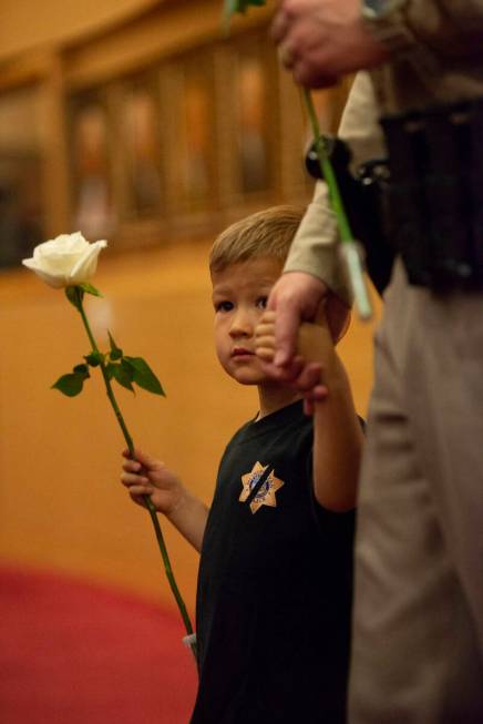 Liam Walker, 4, holds his father Lt. Dave Walker's hand as they enter the Las Vegas City Counci ...
