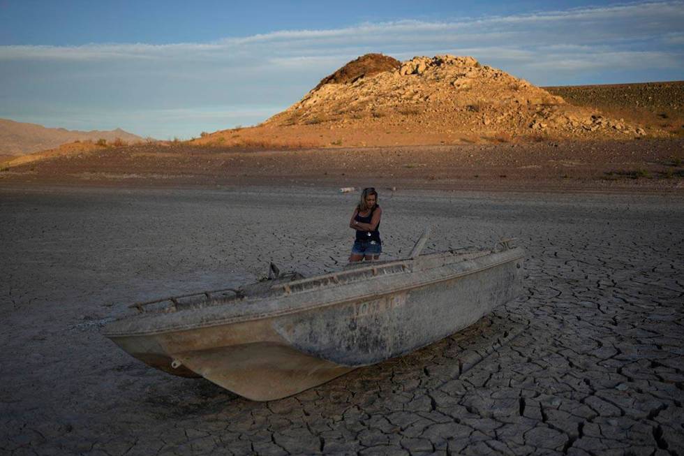 Misha McBride looks at a formerly sunken boat now on cracked earth hundreds of feet from what i ...