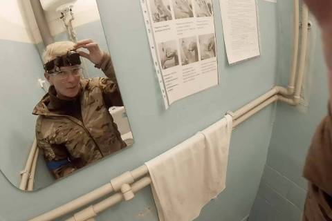 Yuliia Paievska, known as Taira, looks in the mirror and turns off her camera in Mariupol, Ukra ...