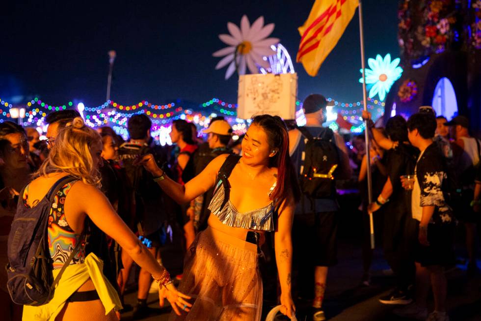 Attendees dance underneath the glow of the fire rings during the first day of the Electric Dais ...