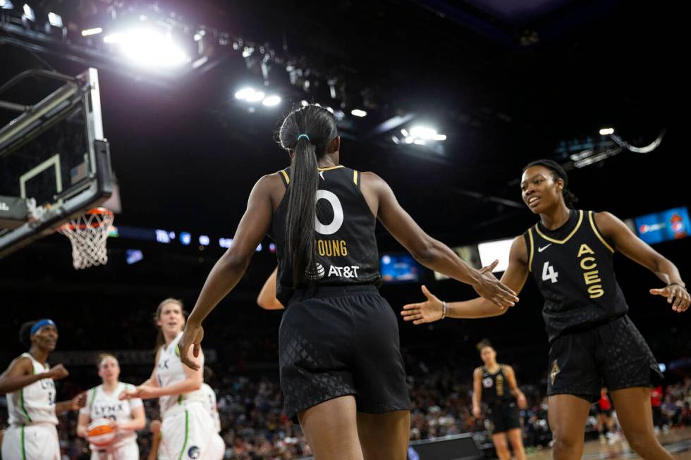 Las Vegas Aces guard Jackie Young (0) slaps hands with guard Aisha Sheppard (4) during the seco ...