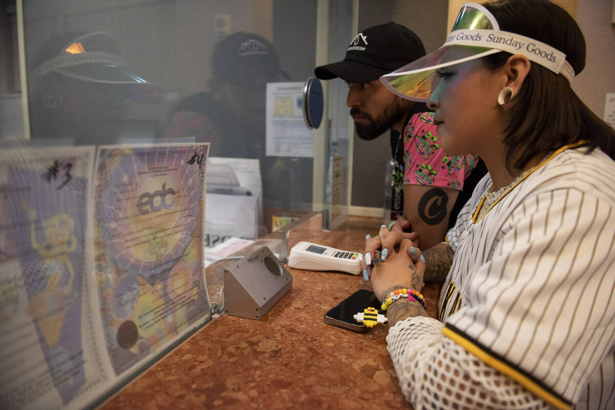 Jessica Avila, left, and Carlos Mendez get their EDC-themed marriage license at the Clark Count ...