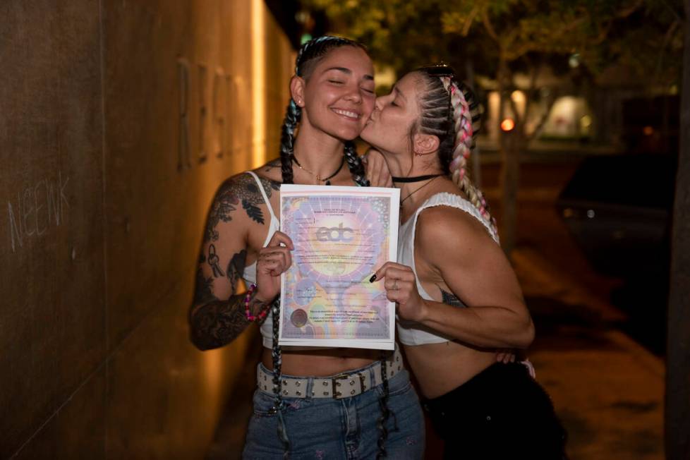 Alix Washington, left, and Cyndel Magalhaes pose with their EDC-themed marriage license at the ...