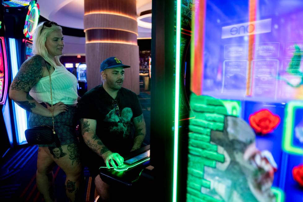 Sierra Johnson, left, and Drew McKenna, of Portland, Ore., play the slot machines at Circa on T ...