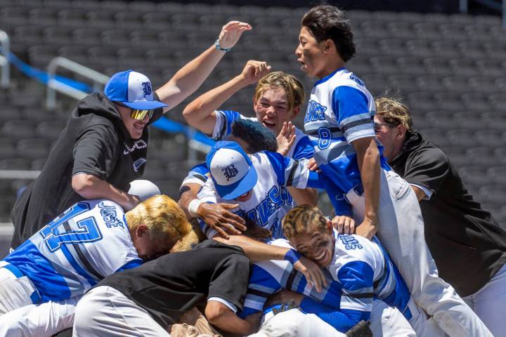 Basic players "dog pile" on the pitcher's mound in celebration of defeating Bishop Go ...