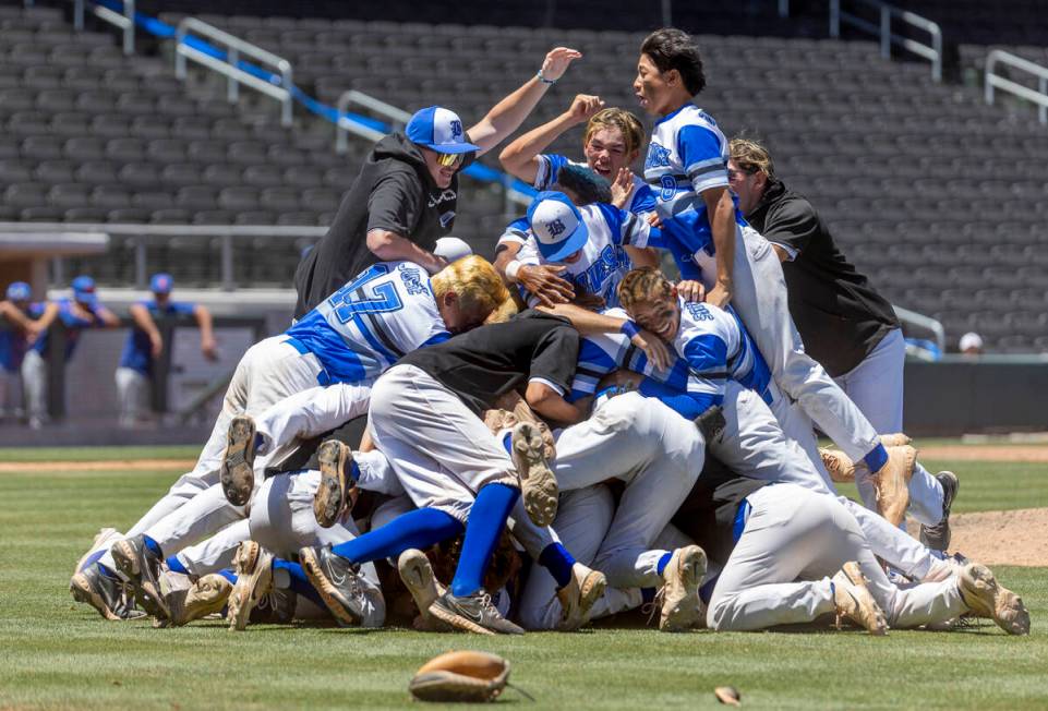 Basic players "dog pile" on the pitcher's mound in celebration of defeating Bishop Go ...