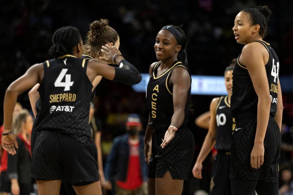 Las Vegas Aces guard Aisha Sheppard (4) slaps hands with guard Jackie Young, center, during the ...