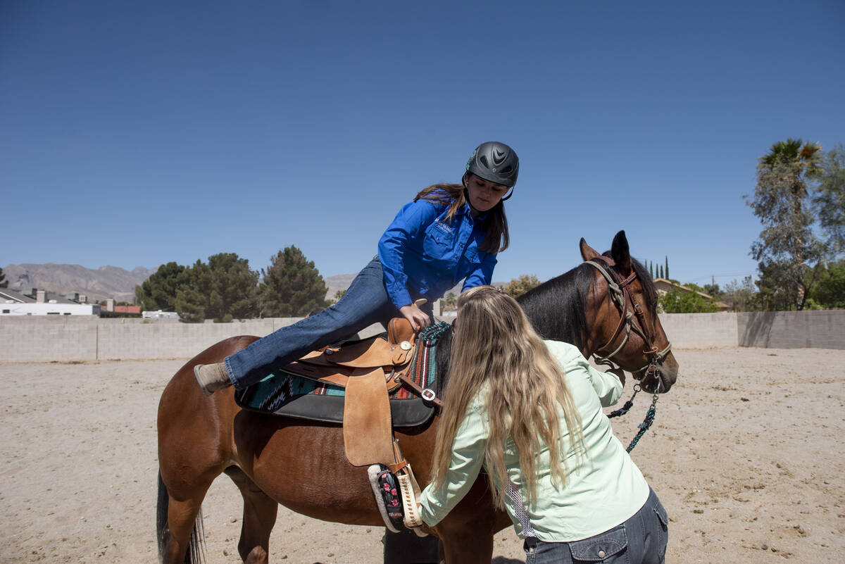 With the help of her riding instructor Dania Spor-Orellana, Bailey King mounts her new horse, S ...
