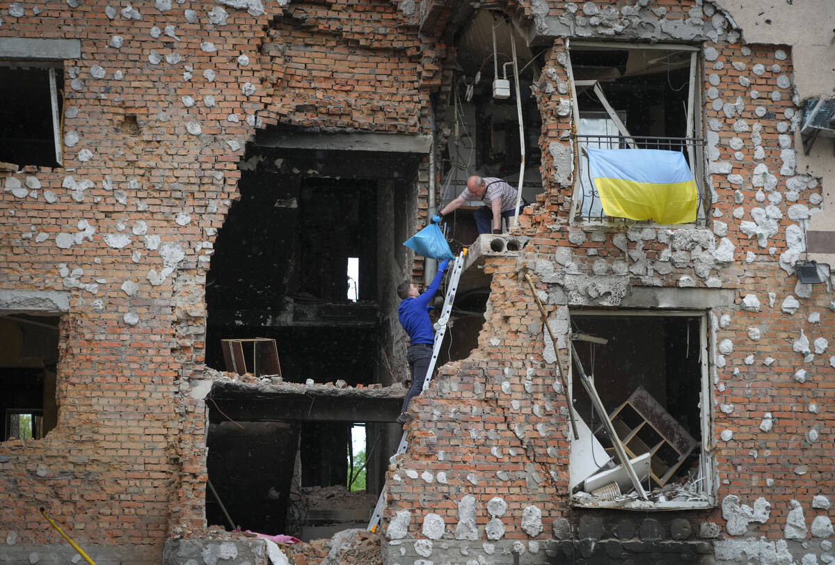 Residents take out their belongings from their house ruined by the Russian shelling in Irpin cl ...