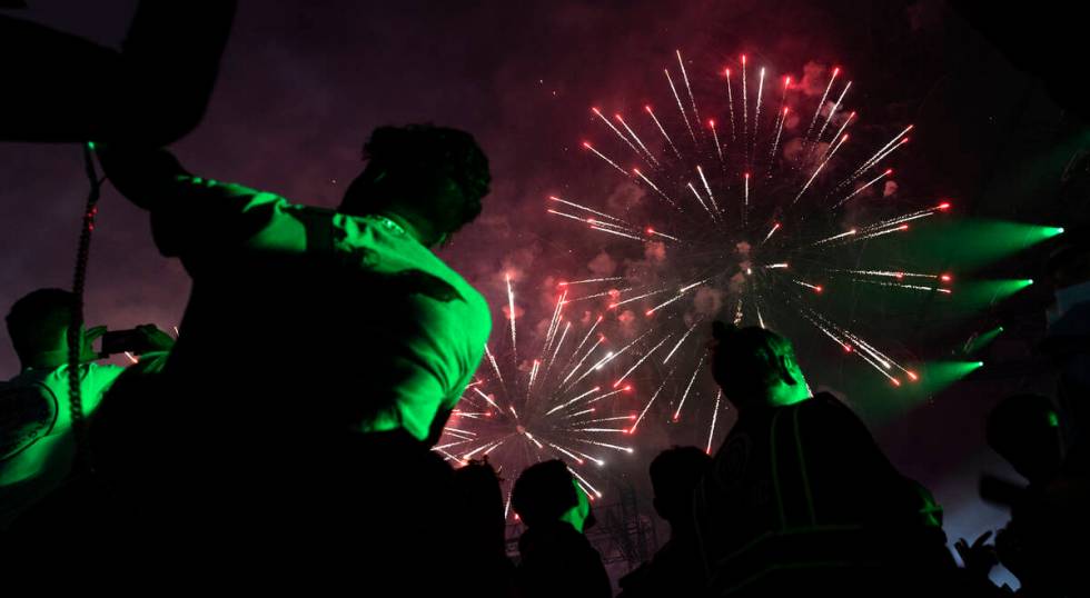 Attendees photograph the fireworks show during the second day of the Electric Daisy Carnival at ...