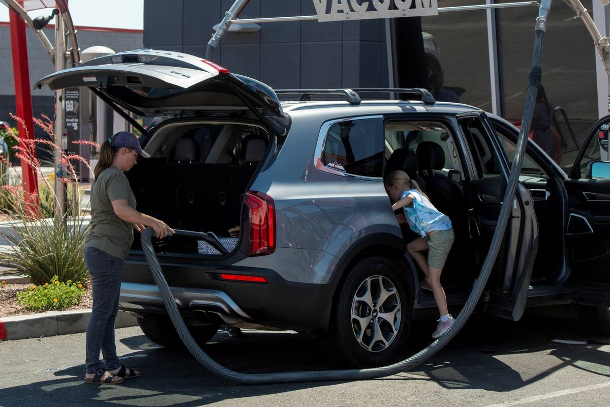 Krista Baker, left, cleans out her car with the help of her children at Tommy's Express car was ...