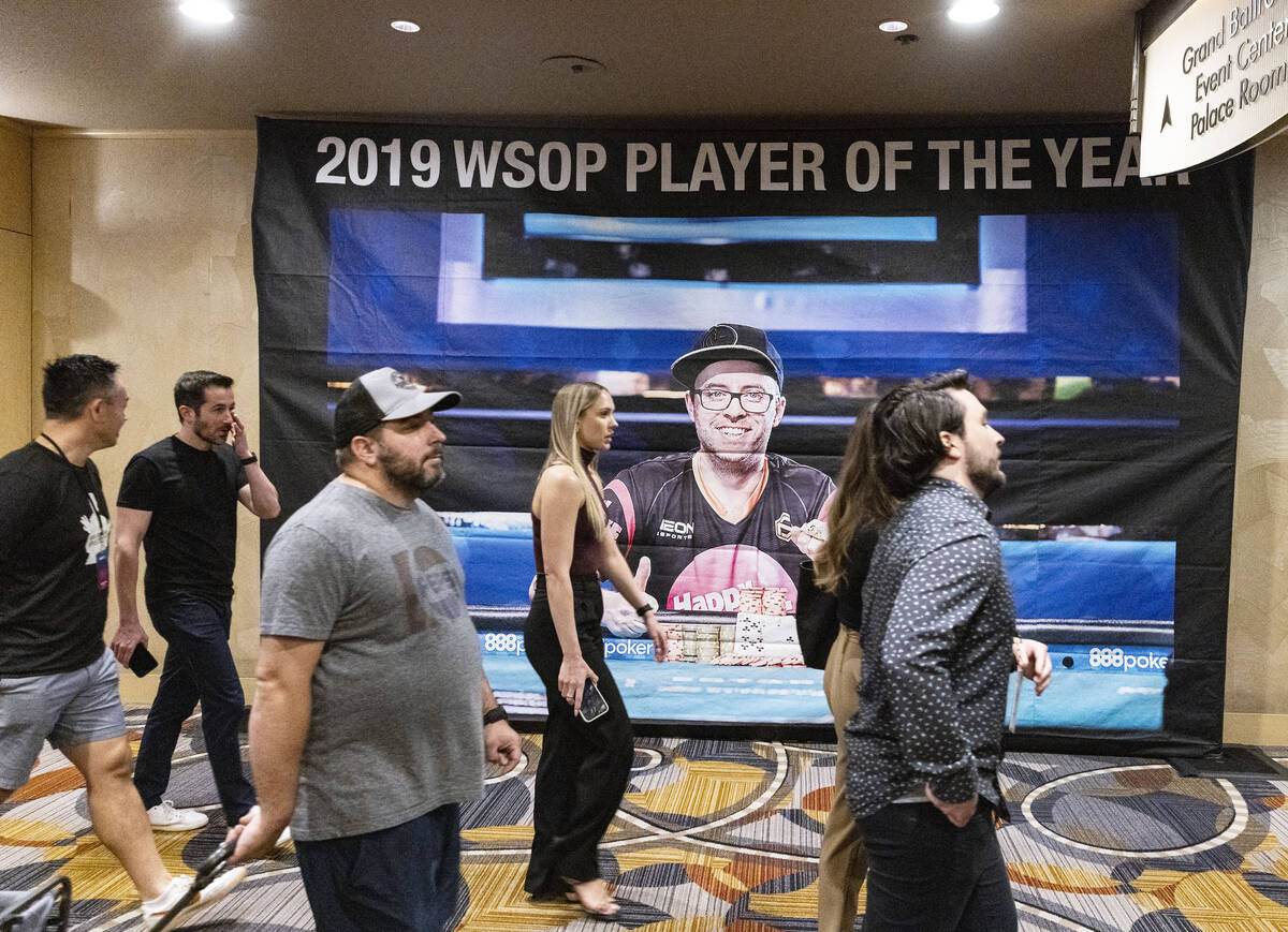 Members of the media walk past the 2019 WSOP player of the year banner at Paris Las Vegas on Th ...