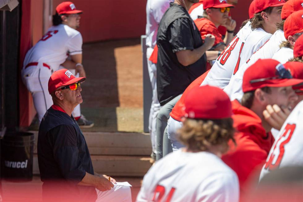 UNLV head coach Stan Stolte, left, watches the game against UNR from the dugout during an NCAA ...