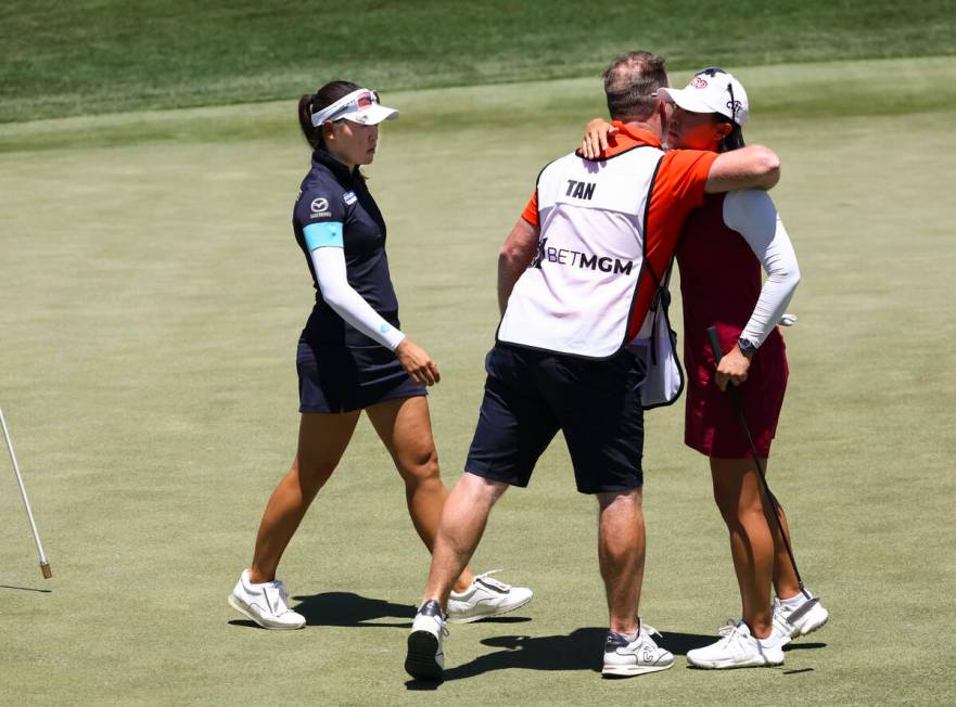 Kelly Tan, left, and her caddy embrace Danielle Kang after Kang lost to Tan at the 12th hole du ...