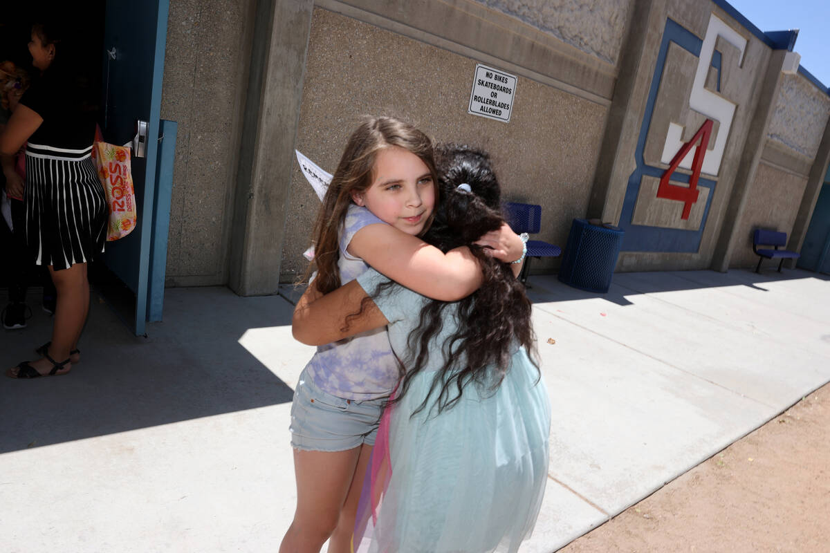 Third graders Shea Shultzman, 8, left, hugs Perla Contereas, 9, on the last day of school at Do ...