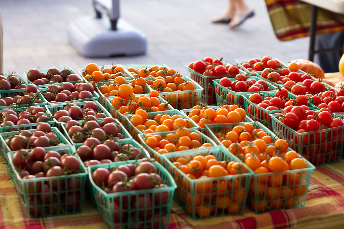 Colorful baskets of tomatoes and other products line the tables at the Fresh 52 farmer's market ...