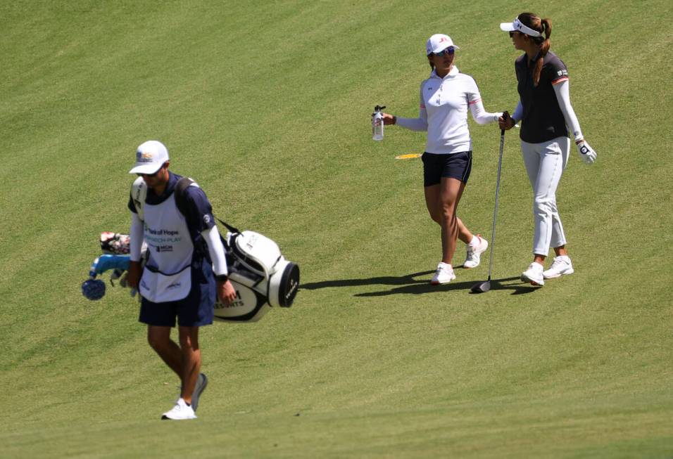 Tiffany Chan, second from left, and Alison Lee talk while walking the fairway at the ninth hole ...
