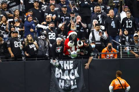Raiders fans in the Black Hole cheer during the first half of an NFL football game against the ...