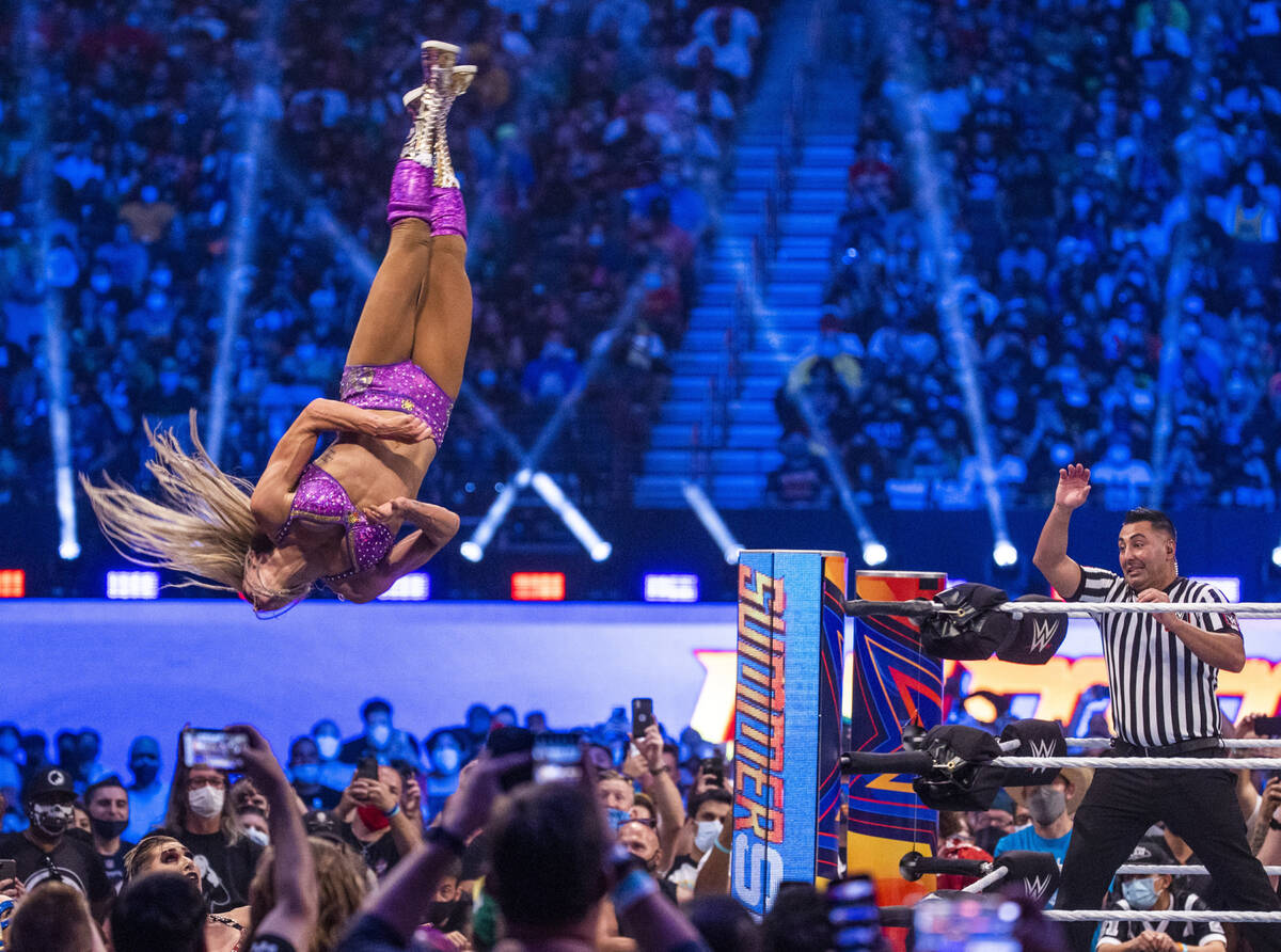 Charlotte Flair flies off the top ropes onto Nikki A.S.H. and Rhea Ripley below in the Raw Wome ...