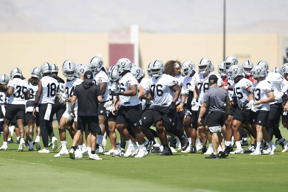 The Raiders, including offensive lineman John Simpson (76), take the field during practice on T ...