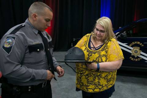 Steven Darnell watches as his mother, Carol, tries to pin his badge after his graduation from N ...