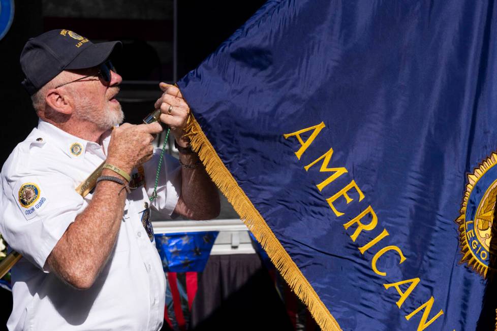Marine Corps veteran Walter Cheatham unfurls the American Legion flag at Lake Sahara South Park ...