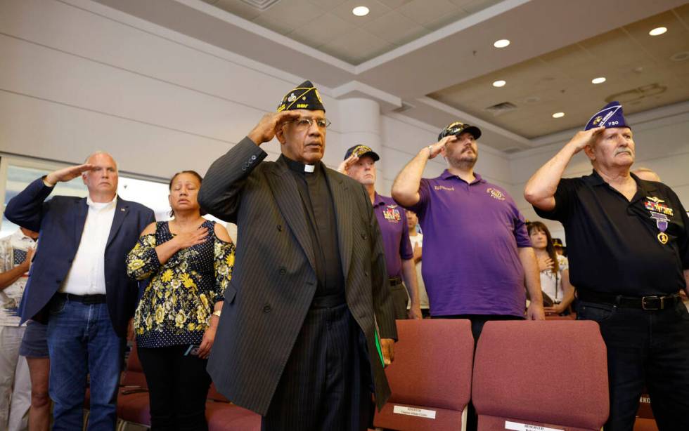 Chaplain Johnny Crosby of Disabled American Veterans Chapter 13, center, salutes during a Memor ...