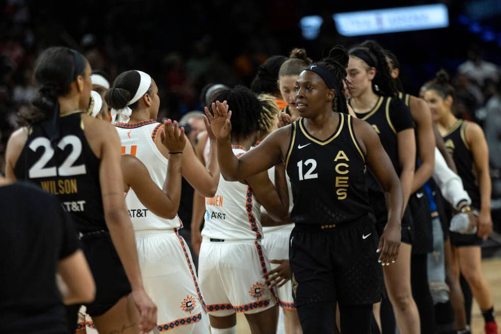 Las Vegas Aces players including guard Chelsea Gray (12) slap hands with the Connecticut Sun af ...