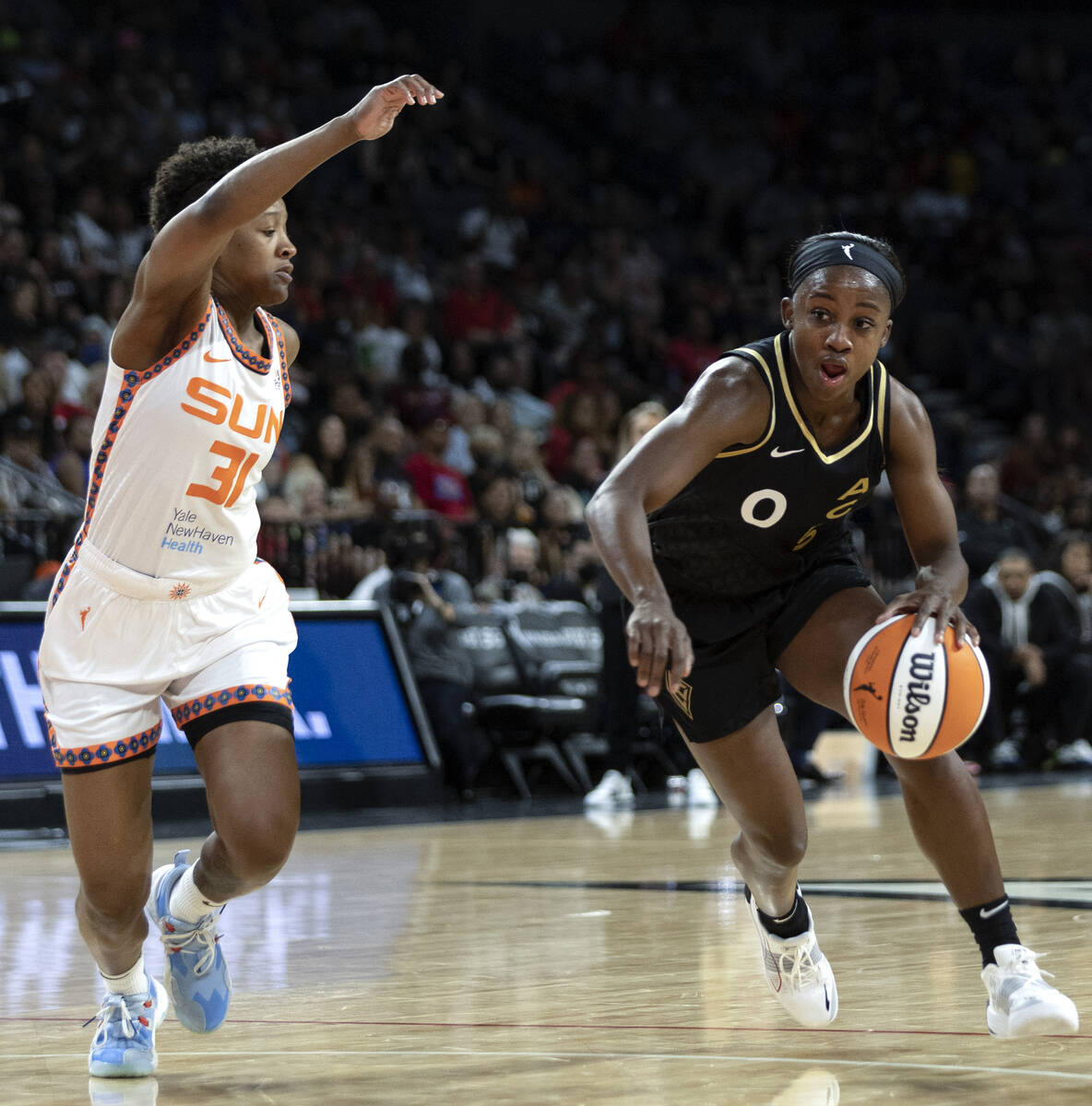 Las Vegas Aces guard Jackie Young (0) drives around Connecticut Sun guard Yvonne Anderson (31) ...