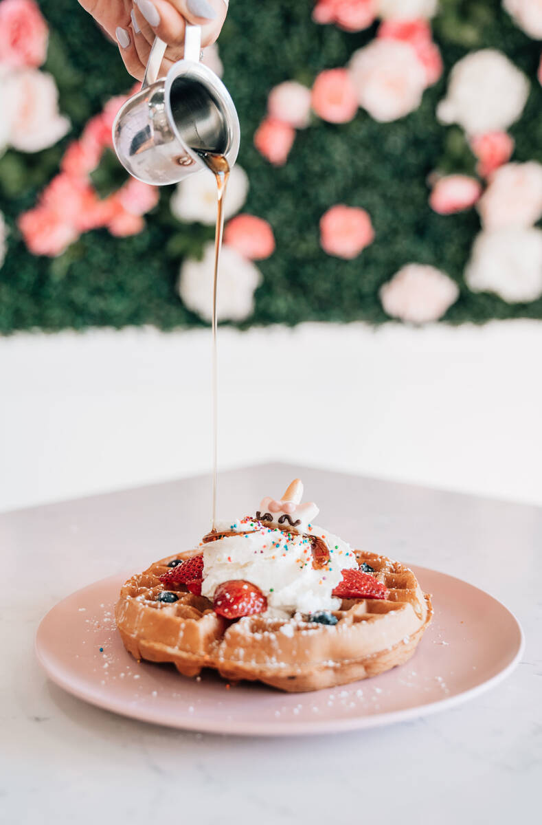 Sprinkles, cream, strawberries and a unicorn cookie top the unicorn waffle at Café Lola. ( ...